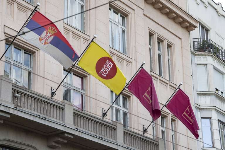 Serbian and branded event flags hanging from the historic building facade during the IMGL Belgrade 2026 event