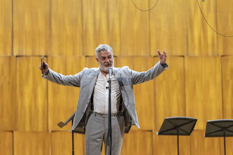 A speaker on stage addressing luxury travel advisors inside the iconic Kolarac concert hall
